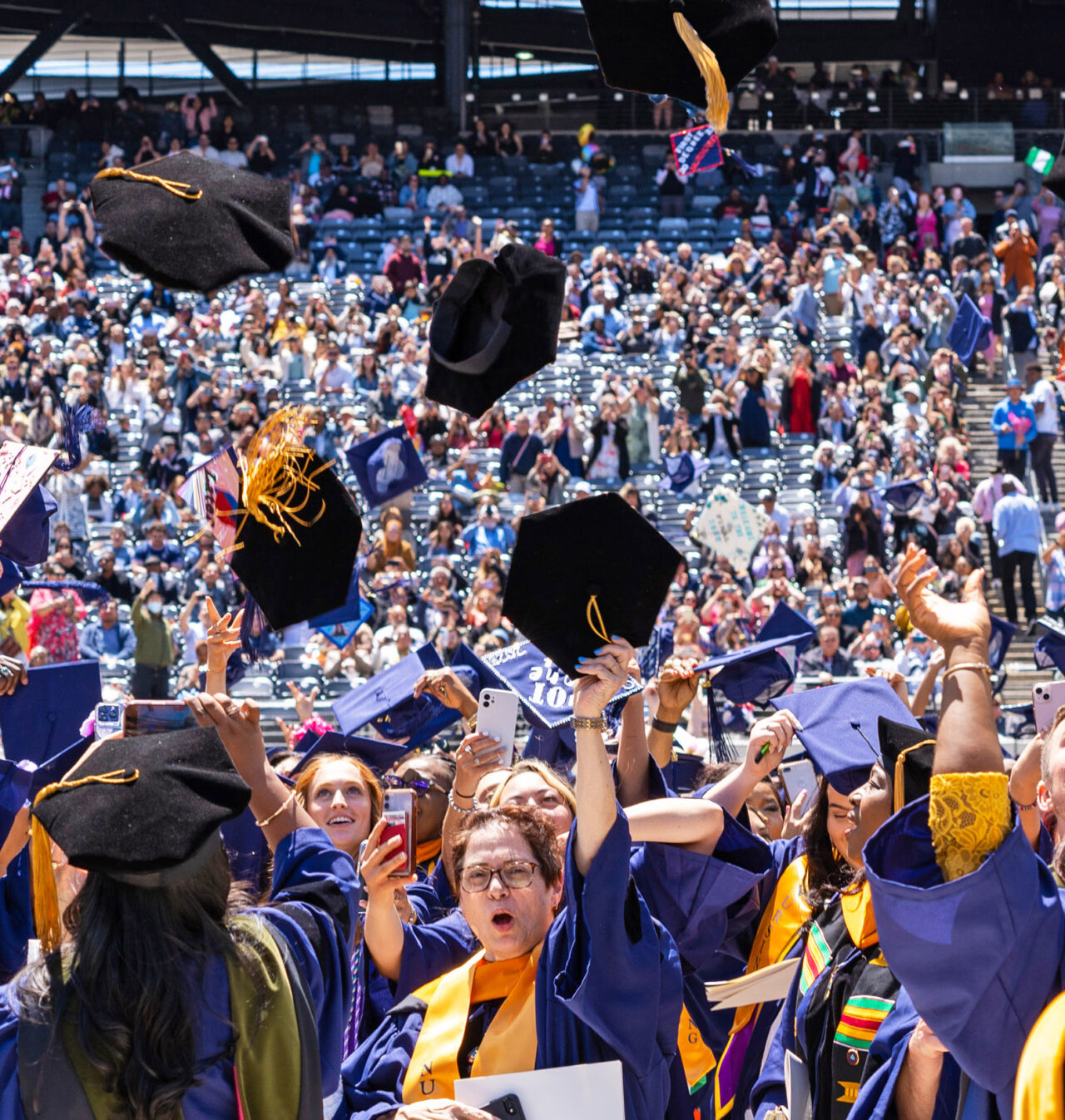 Graduates throw their caps in the air.