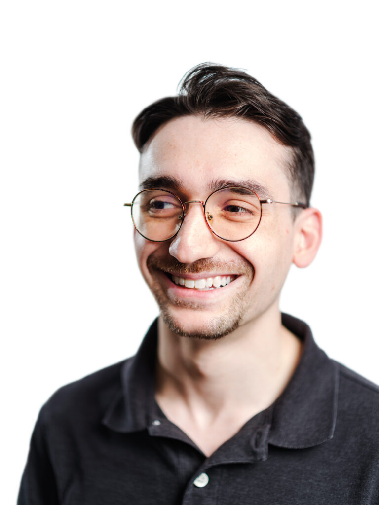 Portrait of a young man wearing a polo shirt and glasses.