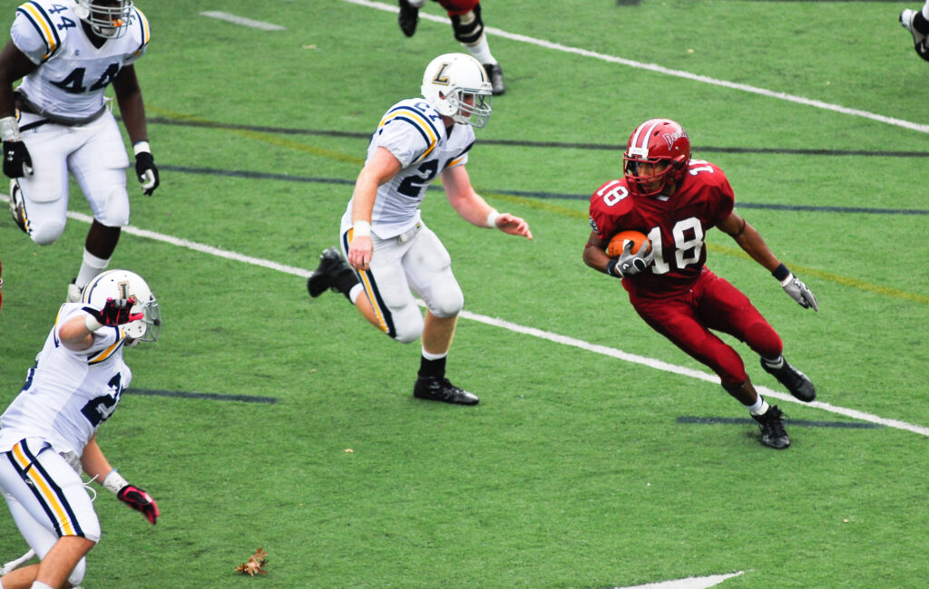 An FDU Devils football player runs to avoid a tackle. 