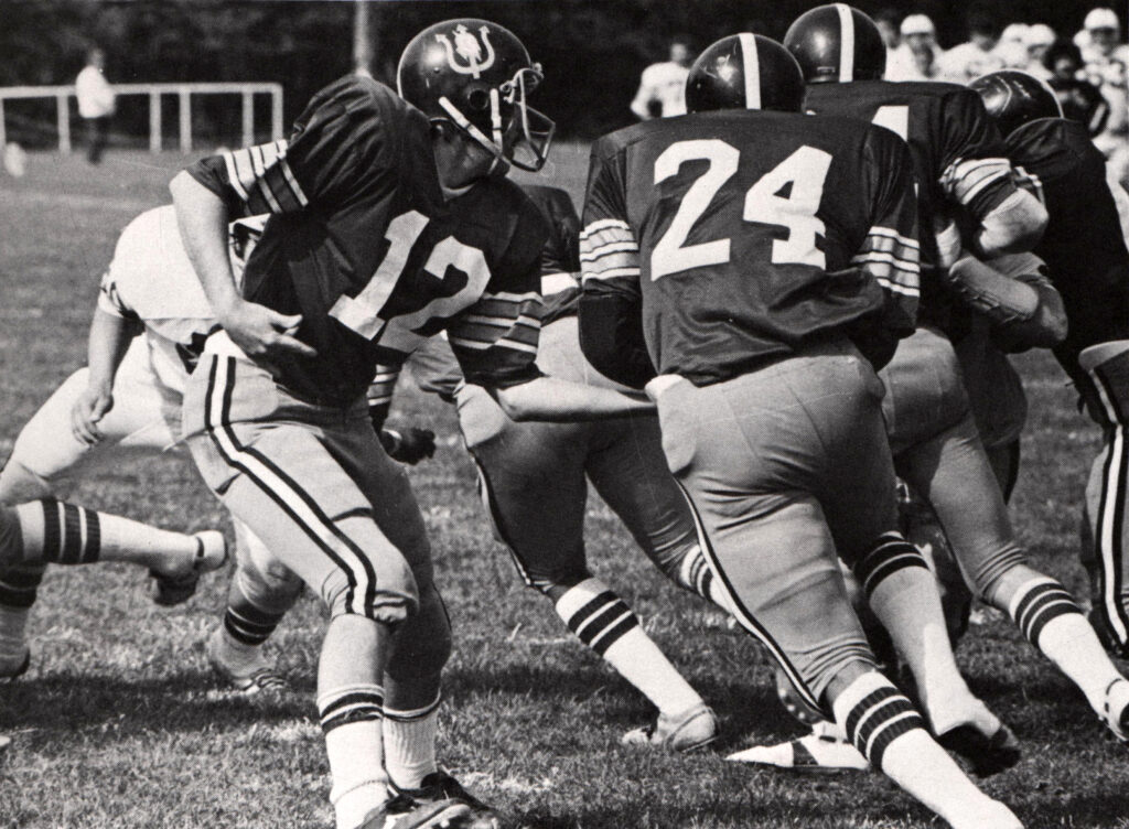 football players in the middle of a game. the photo is in black and white.