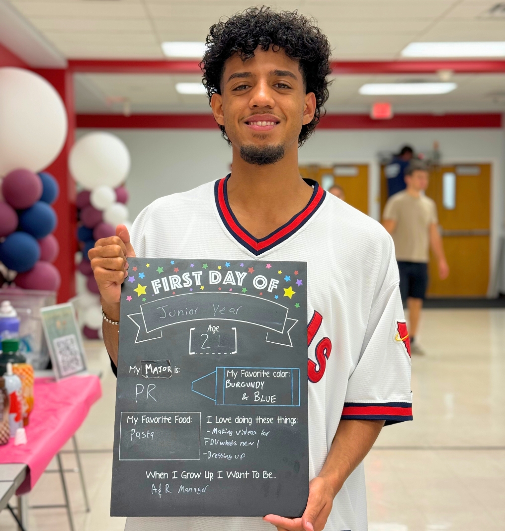 a student holds up a chalk board that reads 