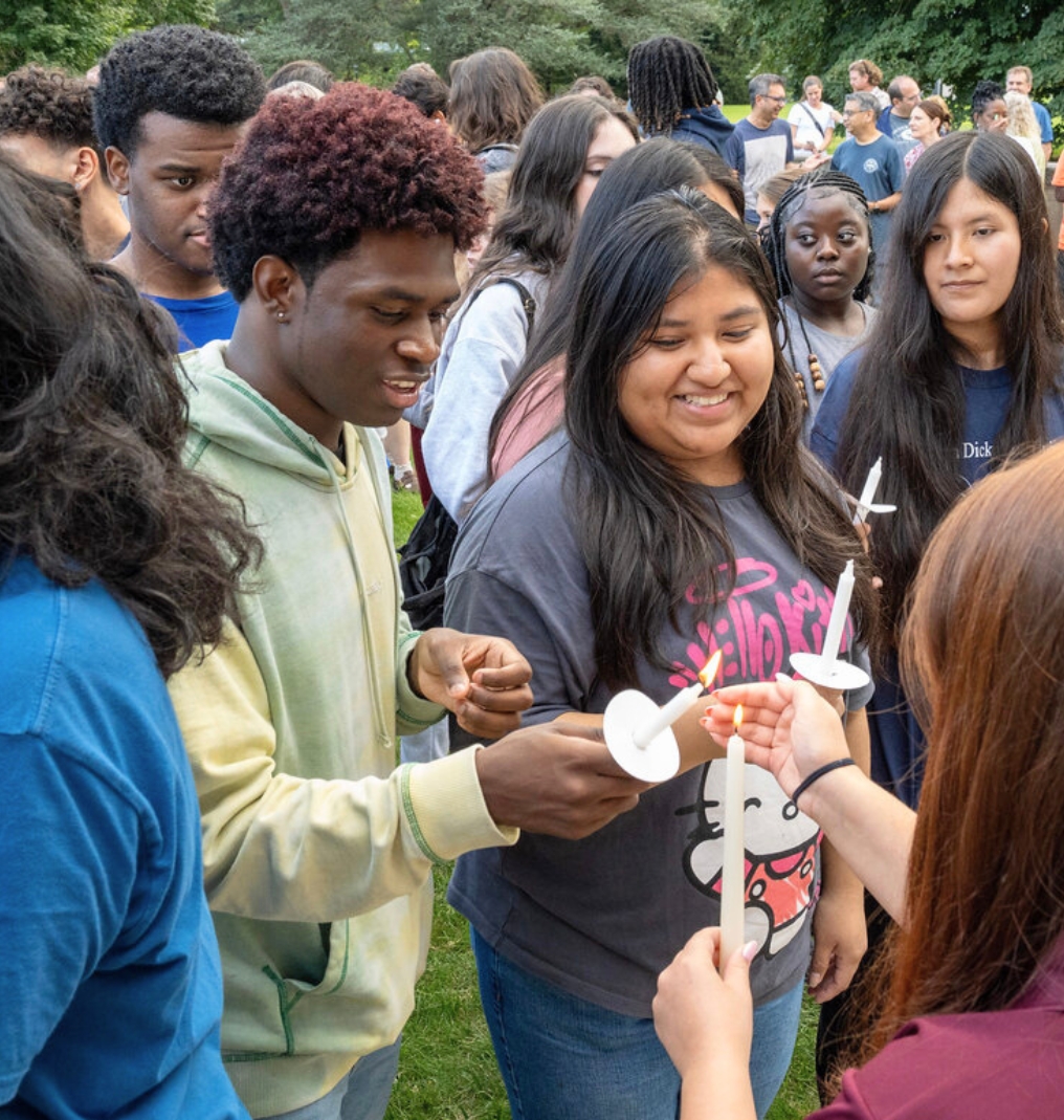 students lighting candles in a ceremony