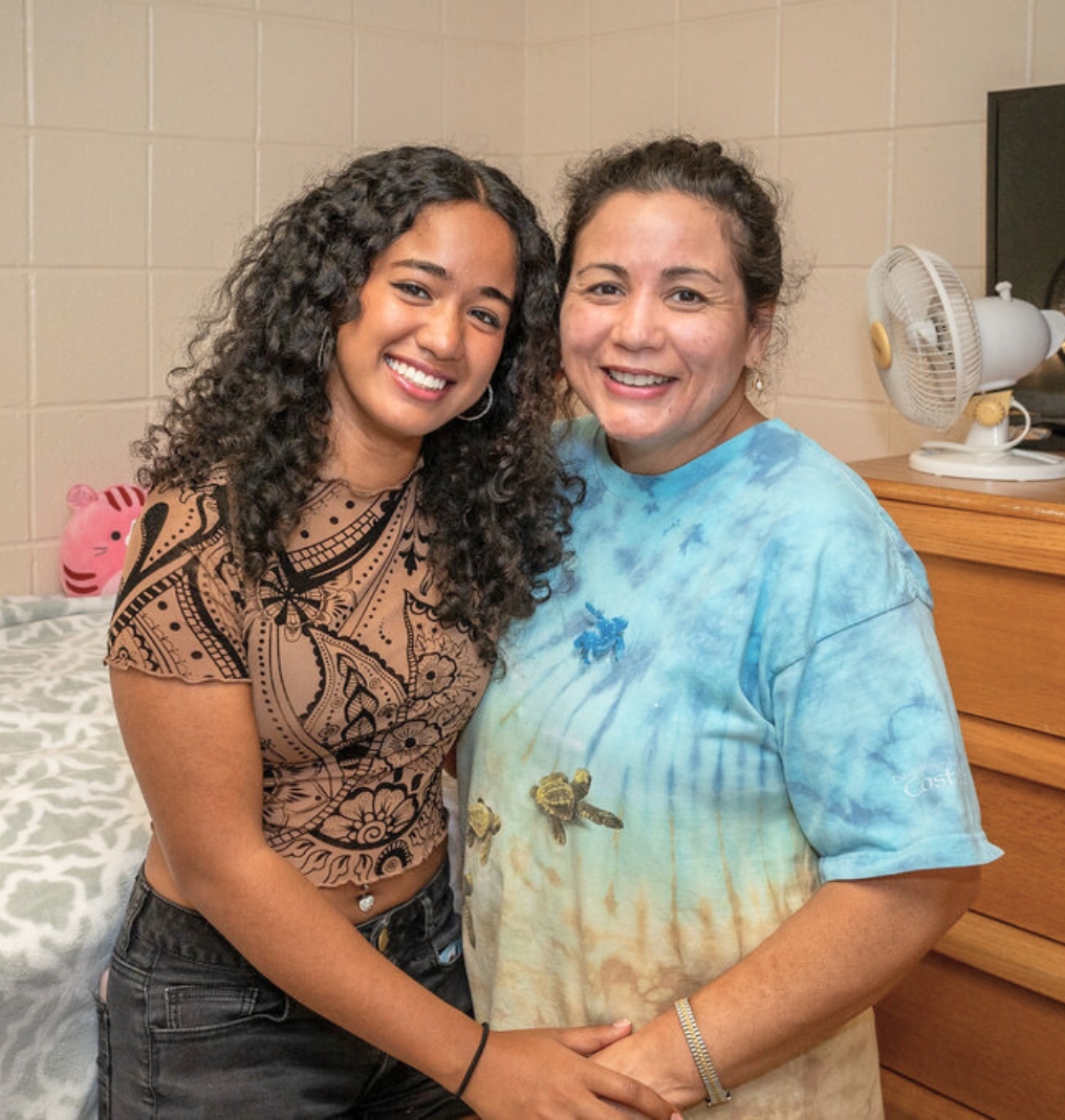 a student and her mother smile at the camera.