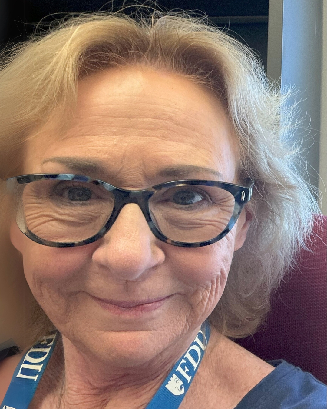 portrait of a woman wearing glasses and a FDU lanyard.