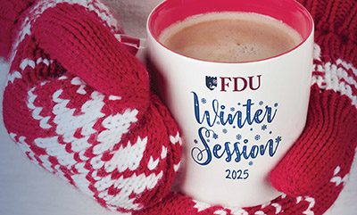 Hands in winter mittens hold a coffee mug that reads FDU Winter Session.