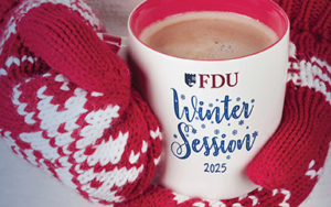 Hands in winter mittens hold a coffee mug that reads FDU Winter Session 2025.