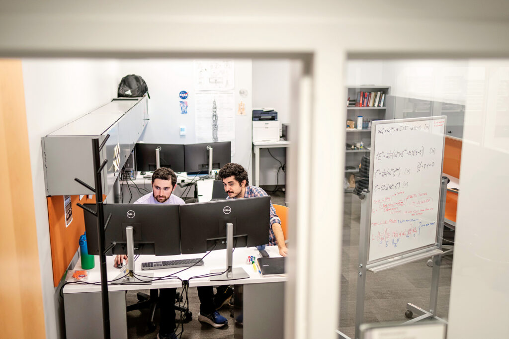 Two men work on computers in a lab.