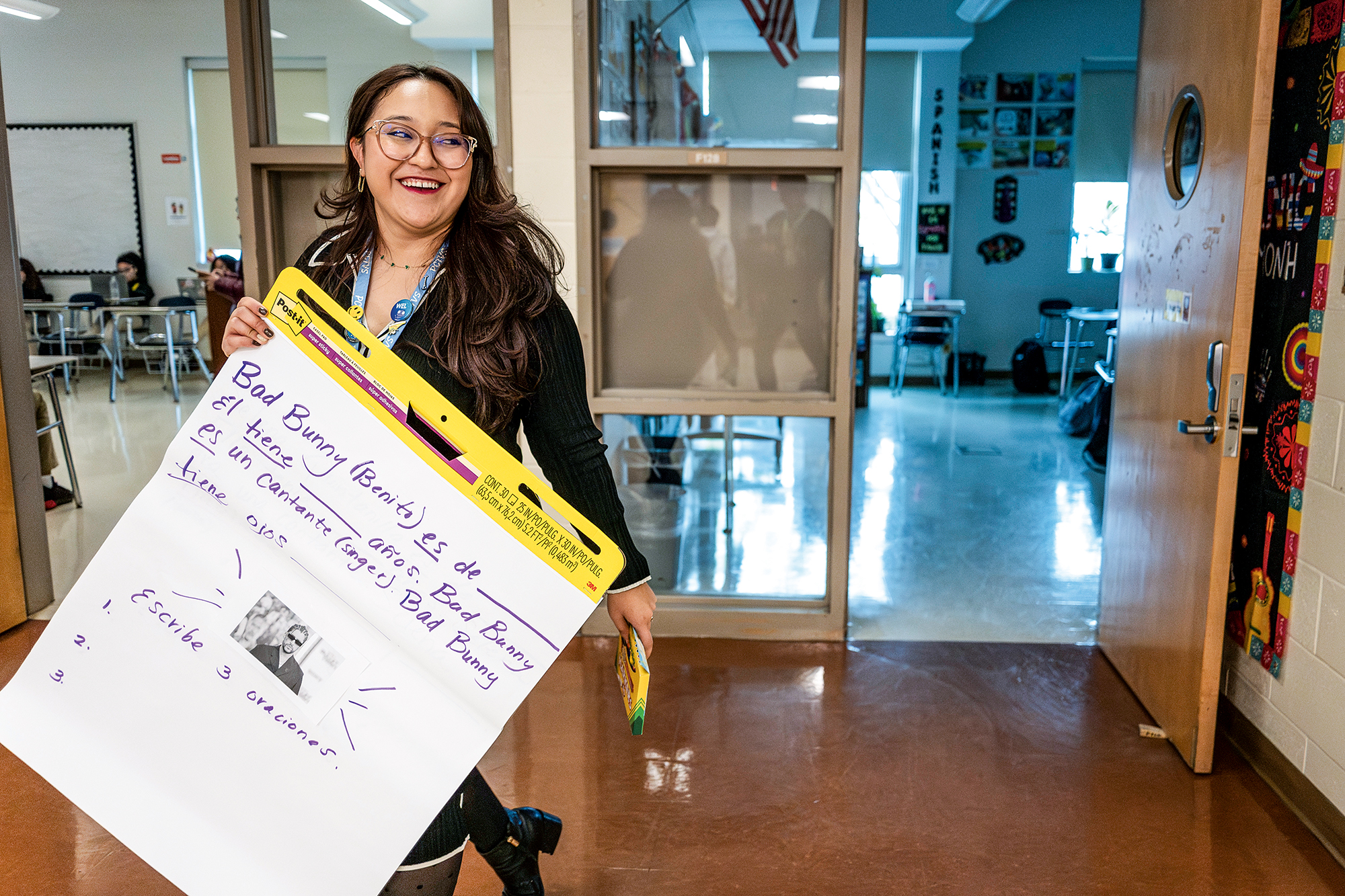 A woman holds up a large notepad with information about Puerto Rican rapper Bad Bunny.