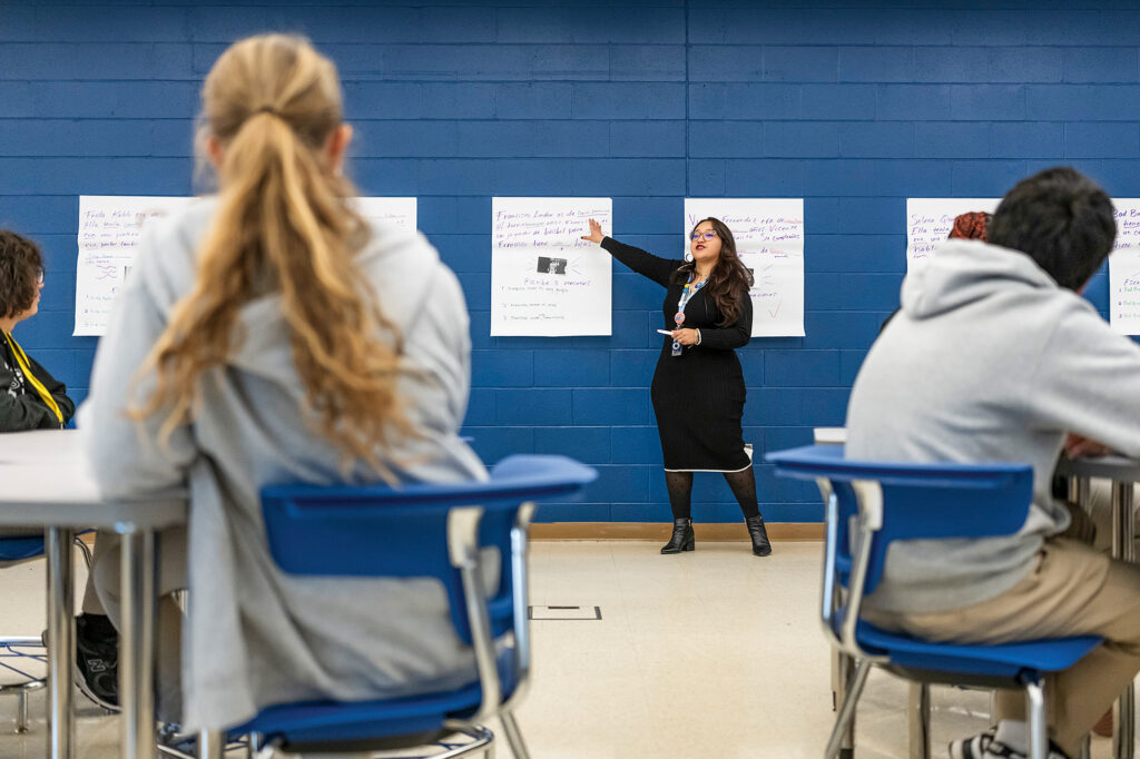 A woman teaches at the head of the class.