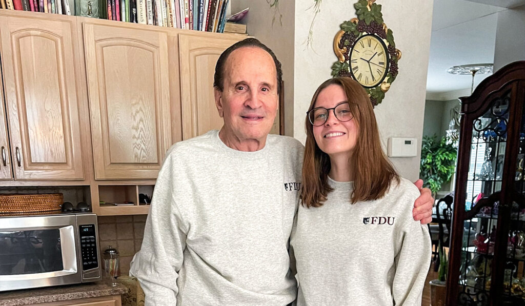 A senior citizen and young woman show offer their matching FDU t-shirts.