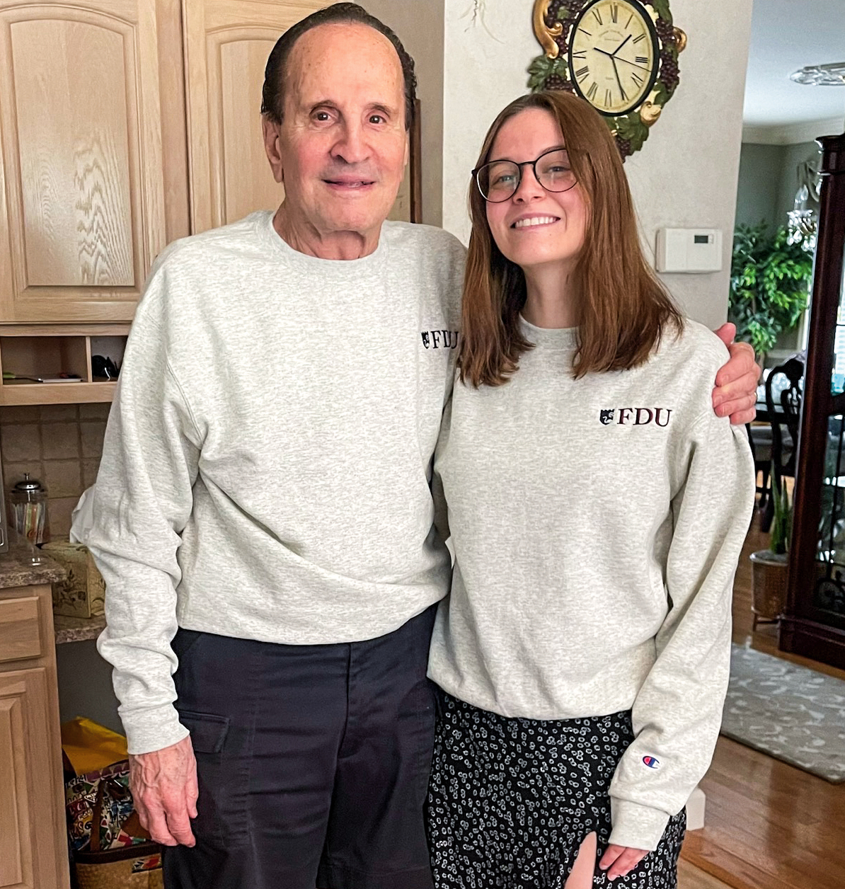 A senior citizen and young woman show offer their matching FDU t-shirts.