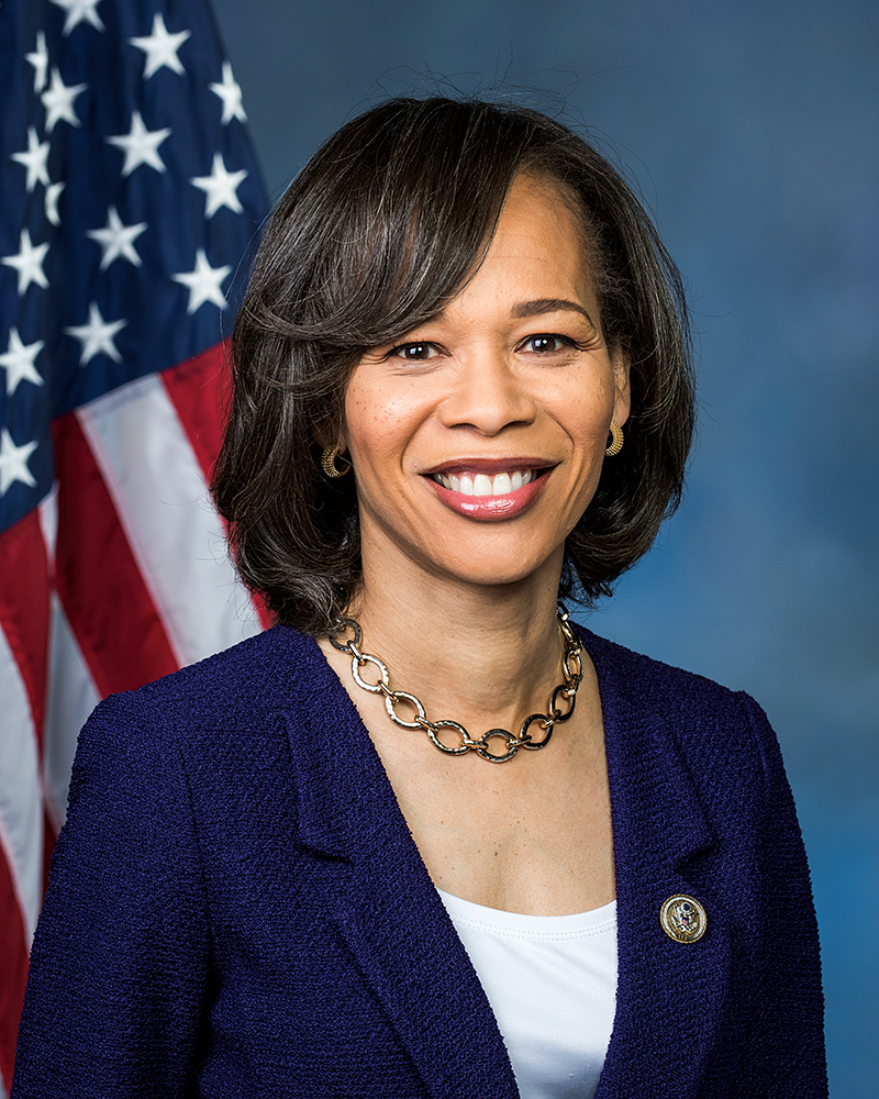 Portrait of a woman with an American flag in the background.