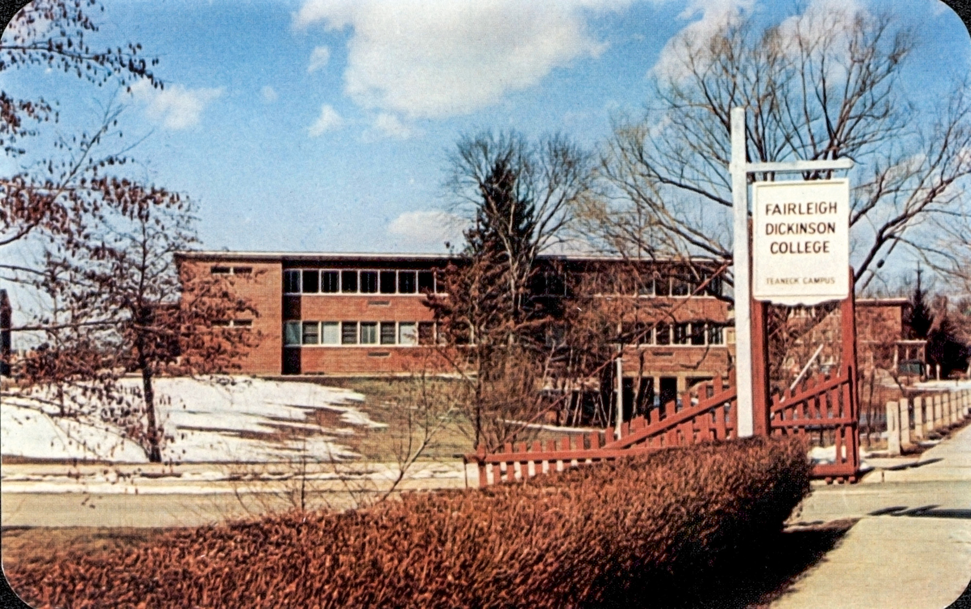 A vintage postcard of a large brick building with an old-fashioned white wood sign.