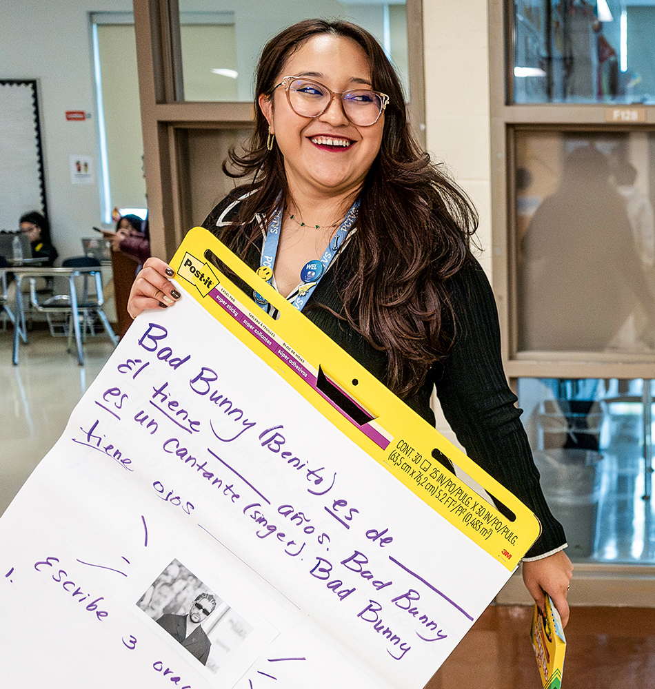 A woman holds up a large notepad with information about Puerto Rican rapper Bad Bunny.