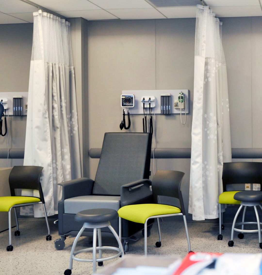 Health exam room with blood pressure cudd and exam table.