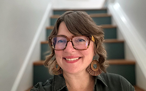 Close up portrait of a woman wearing glasses and earrings.