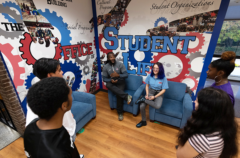 Students and staff chat outside of the Student Life offices at the Metro Campus.