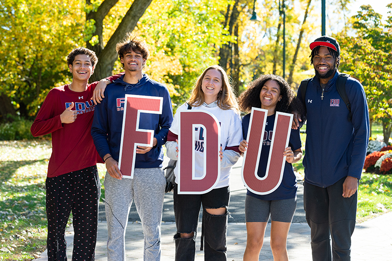 Five students pose for a photo with the FDU letters.