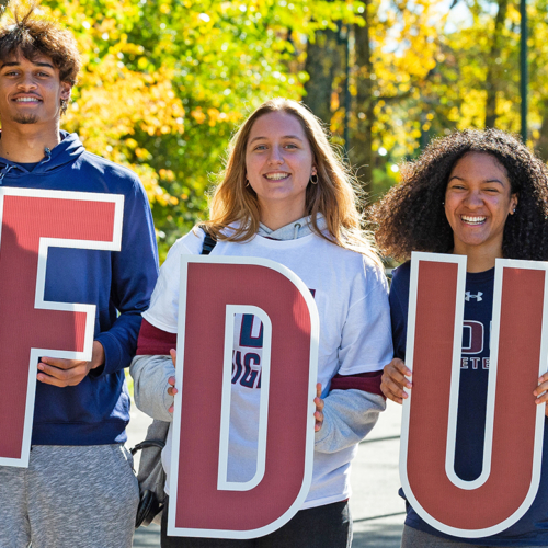 Five students pose for a photo with the FDU letters.